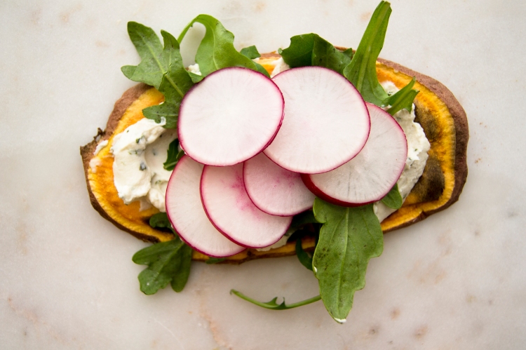 sweet potato toast topped with cream cheese, arugula greens and sliced radish toppings